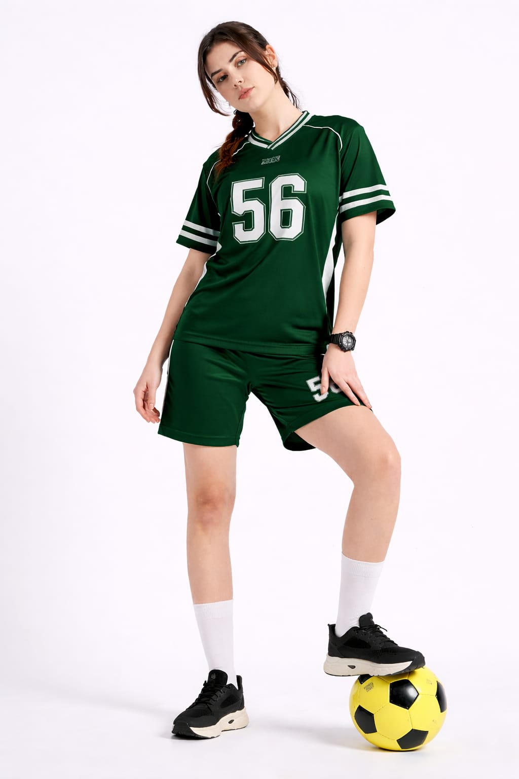 Person wearing a green sports uniform with the number 56, standing next to a soccer ball on a white background